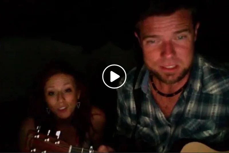 Jon and Victoria singing together with guitars