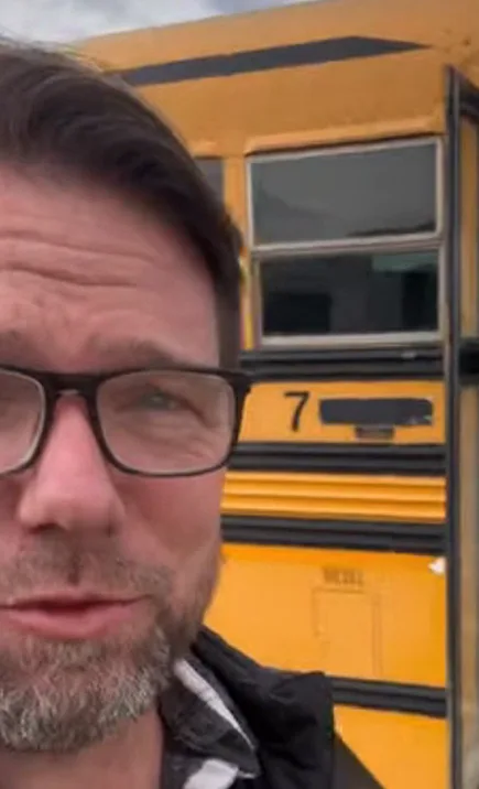 Jon in a close selfie next to a yellow school bus